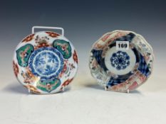 A JAPANESE IMARI BOWL, THE WAY EDGED RIM PAINTED WITH ALTERNATING LANDSCAPE AND BROCADE PANELS. Dia.