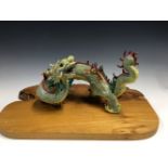 A CHINESE PORCELAIN FOUR HORNED DRAGON, ITS BLUE DIAPERED YELLOW BODY WITH A RED SPINE, SEAL MARKS