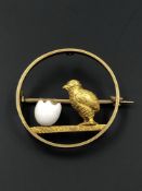 AN ANTIQUE CHICK AND ENAMELLED EGG BROOCH. THE BROOCH STAMPED 15C CO? TO THE REVERSE, ASSESSED AS