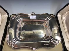 A CASED SILVER CAKE BASKET BY ATKIN BROTHERS, SHEFFIELD 1896, THE WAVY RECTANGULAR RIM OVERSWUNG