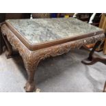 A GREEN STONE TOPPED MAHOGANY LOW TABLE WITH FOLIATE CARVED APRON ON DOLPHIN CABRIOLE LEGS WITH MASK