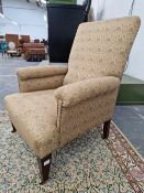 A LATE VICTORIAN LARGE ARMCHAIR WITH MORRIS STYLE UPHOLSTERY STANDING ON STOUT SQUARE TAPER