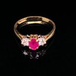 A RUBY AND DIAMOND THREE STONE TRILOGY RING. THE CENTRAL CUSHION CUT RUBY IN A CLAW SETTING,