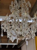 A TEN BRANCH CHANDELIER, EACH ARM HUNG WITH DROPS AND CURVING UP TO MEET THE CEILING SUSPENSION. H