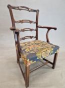 A GEORGE III MAHOGANY LADDER BACKED ELBOW CHAIR WITH A NEEDLE WORK SEAT ABOVE THE CANTED SQUARE