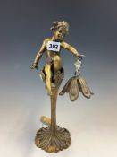 A BRONZE TABLE LAMP, THE PETAL SHADE HELD UP BY A PUTTO SEATED WITHIN THE CALYX OFA STALK. H 31cms.