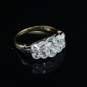 A VINTAGE OLD CUT DIAMOND RING. THE TEN OLD CUTS DIAMONDS IN A GRADUATED TWO ROW RUBOVER SETTING.