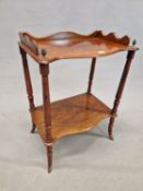 A 19th C. ROSEWOOD TWO TIER STAND, THE FRONT OF THE THREE QUARTER GALLERIED TOP WITH BRASS PINEAPPLE