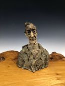 A SCULPTED POTTERY BUST OF A MAN WEARING A BLUE TINTED JACKET. H 21cms.