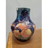 A WALTER MOORCROFT VASE SLIP TRAILED WITH BIRDS AMONGST FRUIT ON A SHADED BLUE GROUND. H 34cms.