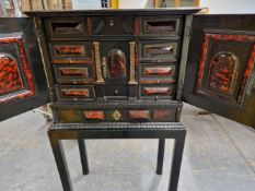 AN INTERESTING EARLY EBONISED AND TORTOISESHELL CABINET, THE PANEL DOORS WITH HEART MOTIF
