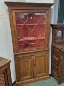 A GEORGE III PINE CORNER CUPBOARD WITH AN ASTRAGAL GLAZED DOOR OVER AND PAIR OF PANELLED DOORS AND A