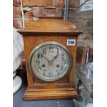 AN EARLY 20th C. OAK CASED MANTEL CLOCK STRIKING ON A COILED ROD, THE SILVERED DIAL WITH ARABIC