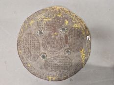 AN INDIAN LEATHER DHAL, THE SHIELD PAINTED WITH FOUR KIDNEY SHAPES ABOUT FOUR METAL BOSSES. Dia.