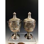 A PAIR OF ANTIQUE HALLMARKED SILVER CLASSICAL STYLE CUPS AND COVERS EACH WITH MASK HANDLES . CHESTER