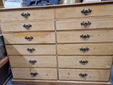 A 20th C. PINE CHEST OF TWO BANKS OF SIX DRAWERS ON A PLINTH FOOT. W 111 x D 31 x H 88cms.