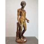 A BRONZE FIGURE OF NARCISSUS STANDING LOOKING DOWN TO WHERE HIS REFLECTION COULD BE SEEN IN WATER,