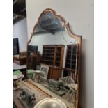 AN ART DECO WAVY ARCHED MIRROR, THE PLATE WITHIN A PINK GLASS FRAME. 157 x 147cms.
