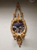 A PAIR OF CONVEX GIRANDOLE MIRRORS THE GILT FRAMES WITH TRIANGULAR VINE TOP SUPPORTS, THE CRESTING