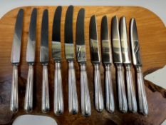 A SET OF THREE SILVER HANDLED STAINLESS STEEL TABLE KNIVES BY GARRARDS, SHEFFIELD 1941, THREE