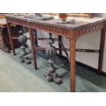 A GRANITE TOPPED ROSEWOOD CONSOLE TABLE, THE APRON CARVED WITH AN OGEE ARCH BAND ABOVE SIX SQUARE