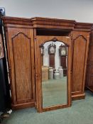 A VICTORIAN MAHOGANY BREAKFRONT COMPACTUM, THE CENTRAL MIRRORED DOOR FLANKED BY PANELLED DOORS