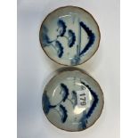 A PAIR OF JAPANESE ARITA BLUE AND WHITE DISHES, EACH PAINTED WITH PINE TREES BEFORE A DISTANT