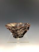 AN ANTIQUE CHINESE RHINOCEROS HORN LIBATION CUP CARVED AS A LOTUS LEAF WITH FURTHER FLOWERS AND