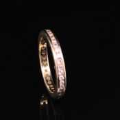A BRILLIANT CUT DIAMOND FULL ETERNITY RING. UNHALLMARKED, STAMPED 750, ASSESSED AS 18ct GOLD. FINGER