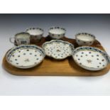 THREE LOWESTOFT TEA BOWLS, A COFFEE CUP, TWO SAUCERS AND A TEA POT STAND. ALL PAINTED WITH