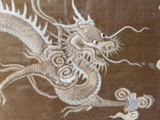 A CHINESE GOLDEN SILK GROUND PANEL EMBROIDERED WITH TWO WHITE DRAGONS HEADING TOWARDS A SACRED