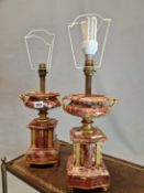 A PAIR OF ORMOLU MOUNTED MOTTLED RED MARBLE TWO HANDLED URNS AS TABLE LAMPS. H 40cms.