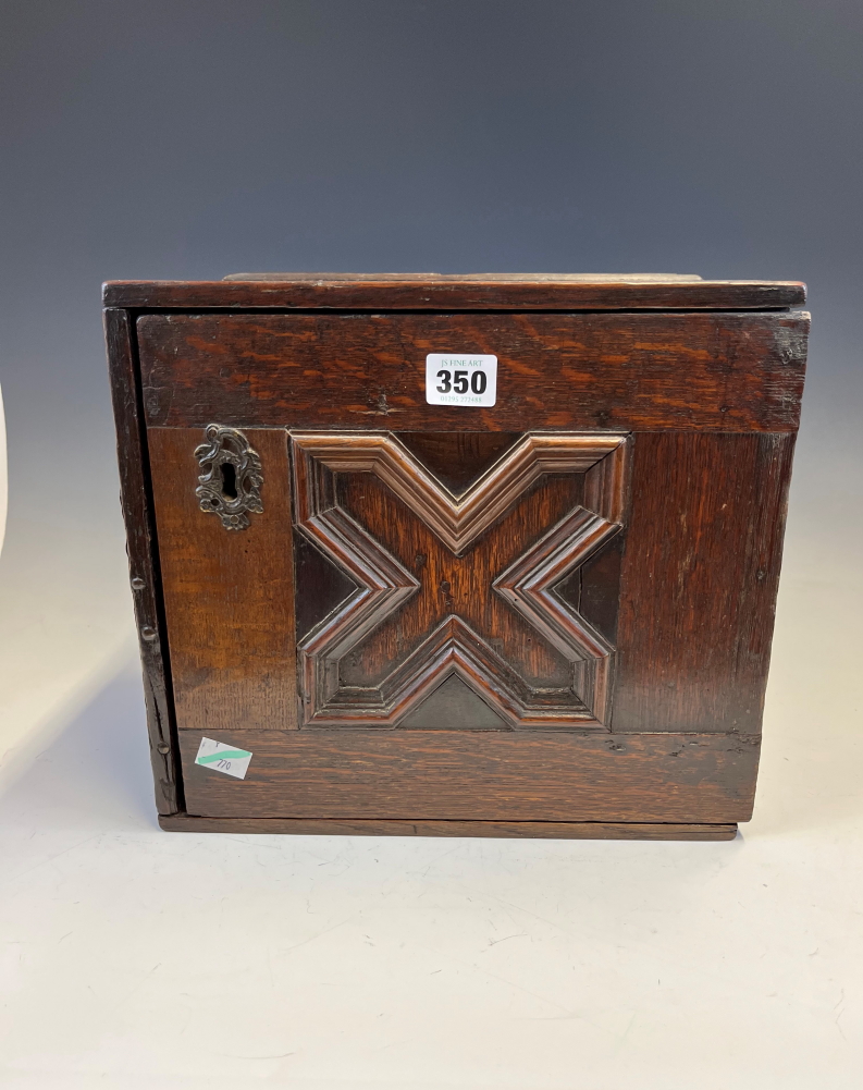 AN 18th C. OAK TABLE TOP CABINET, THE X-SHAPED PANELLED DOOR OPENING ONTO SIX DRAWERS AND TWO PIGEON