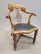 A VICTORIAN WALNUT ELBOW CHAIR, THE BROAD CURVED TOP RAIL ABOVE A PIERCED BALUSTER SPLAT, A GREEN