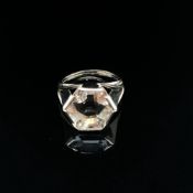 AN UNUSUAL GEMSET AND 18ct HALLMARKED GOLD RING. THE CENTRAL GEMSTONE A HEXAGONAL CUT SET IN A