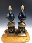 A PAIR OF BRONZE AND ORMOLU OBELISKS, THE REEDED EGG SHAPES WITH FLAMBEAU FINIALS, THE SQUARE