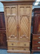 A 19th C. NEOGOTHIC PINE LINEN PRESS, THE PLANK DOORS WITH CARVED FRAMES ENCLOSING SHELVES ABOVE TWO