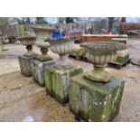 A SET OF FOUR ANTIQUE CARVED STONE SQUARE PLINTHS, EACH SUPPORTING LATER WEATHERED CLASSICAL STYLE