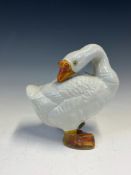 A CHINESE PORCELAIN FIGURE OF A WHITE GOOSE, ITS BEAK AND FEET MOTTLE GLAZED IN ORANGE. H 20cms.