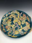 A LISE B MOORCROFT 1992 DISH SLIP TRAILED WITH FISH ON A BLUE GROUND. Dia 41cms.