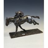 A 20th C. BRONZE HORSE WITH THE JOCKEY CROUCHED OVER ITS NECK, THE RECTANGULAR BASE. W 31.5cms.