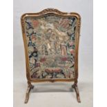 AN EARLY 20th C. MAHOGANY FIRE SCREEN, THE CENTRE OF THE SERPENTINE TOP CARVED WITH FLOWERS, THE