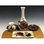 TWO WHITE GROUND MOORCROFT VASES, A RECTANGULAR DISH AND A CIRCULAR GREEN GROUND DISH EACH SLIP