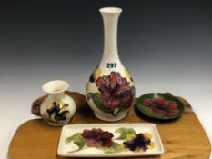 TWO WHITE GROUND MOORCROFT VASES, A RECTANGULAR DISH AND A CIRCULAR GREEN GROUND DISH EACH SLIP