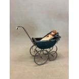 A VICTORIAN BLACK FOUR WHEELED DOLLS PRAM WITH A FOLDING HOOD OVER THE RECTANGULAR WOODEN INTERIOR