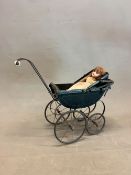 A VICTORIAN BLACK FOUR WHEELED DOLLS PRAM WITH A FOLDING HOOD OVER THE RECTANGULAR WOODEN INTERIOR