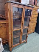 AN ANTIQUE GREY MARBLE TOPPED WALNUT CROSS BANDED ROSEWOOD DISPLAY CABINET, THE TWO GLAZED DOORS B