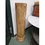 A SIMULATED MOTTLED OCHRE MARBLE CYLINDRICAL COLUMN ON A SOCLE FOOT. H 110cms.