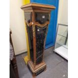 A PAIR OF ORMOLU MOUNTED BLACK MARBLE AND WOOD COLUMNS OF SQUARE SECTION AND TAPERING TO PLINTH