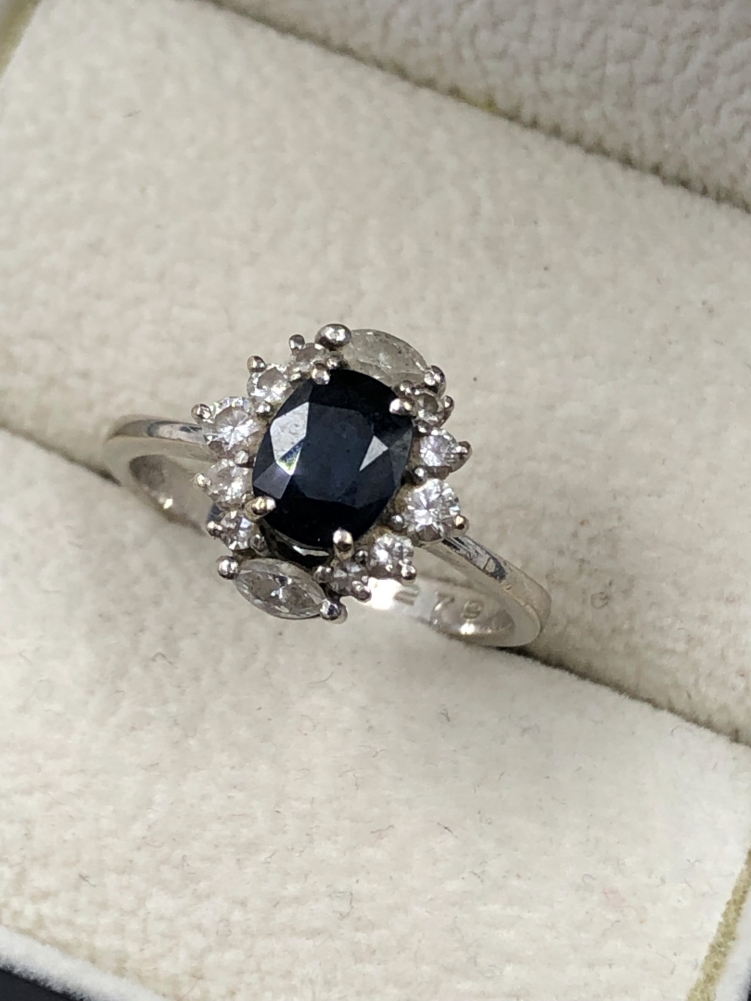 A SAPPHIRE AND DIAMOND CLUSTER RING. THE OVAL SAPPHIRE IN A FOUR CLAW SETTINGS, SURROUNDED BY TWO - Image 6 of 7